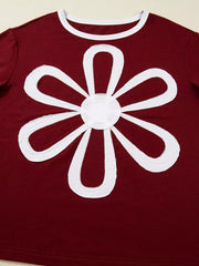 Burgundy long-sleeve top with white flower patch detail and white trim neckline.