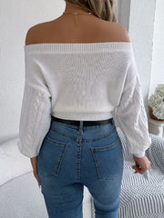White cable knit off-shoulder crop sweater with detailed sleeves.