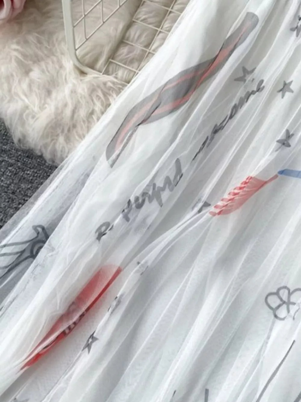 White tulle skirt with abstract sunburst print and text details.