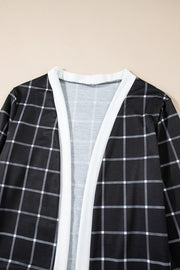 Black and white plaid duster cardigan with white trim and open front.