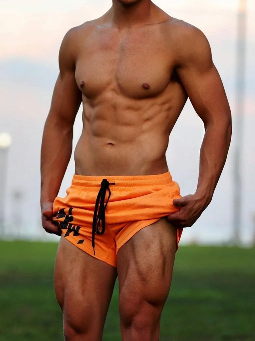 Crew graphic performance shorts in tangerine with black drawstring and graphic detail.