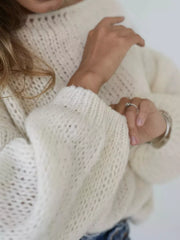 Cream chunky knit sweater with balloon sleeves and boat neck, featuring a loose knit pattern.
