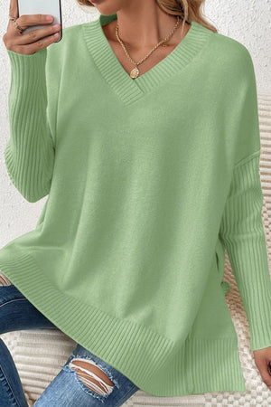 Light green V-neck knit sweater with ribbed sleeves and asymmetric hemline