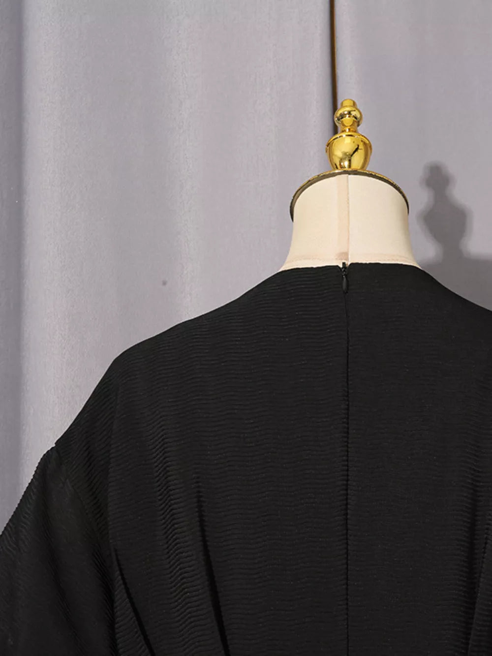 Black midi dress with puff sleeves and textured fabric.