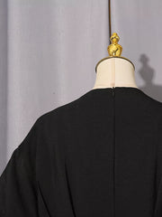 Black midi dress with puff sleeves and textured fabric.