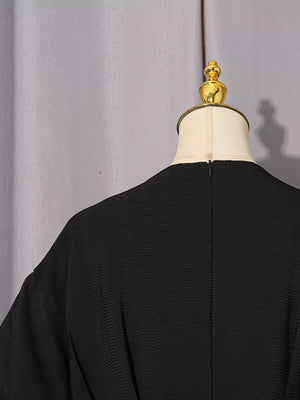 Black midi dress with puff sleeves and textured fabric.