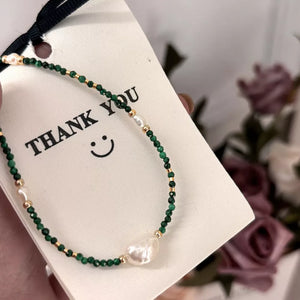 Elegant freshwater pearl and malachite beaded necklace with gold accents.