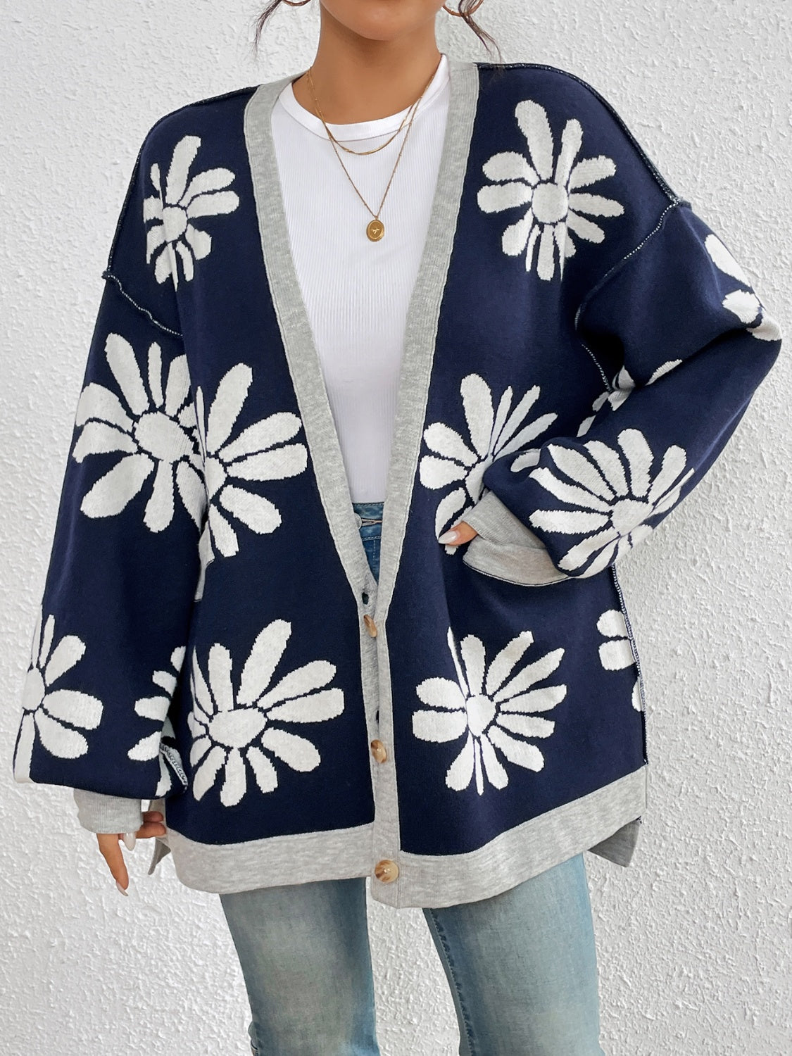 Floral jacquard knit cardigan in dark navy with white daisies and grey trim.
