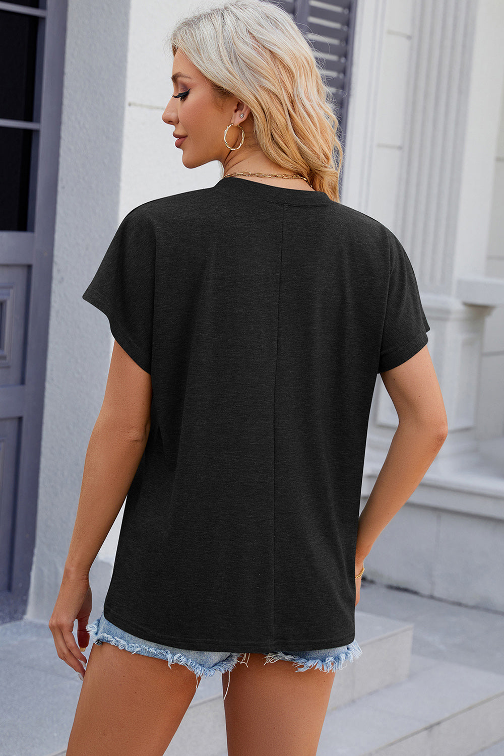 Black dolman sleeve slouchy v-neck top with a relaxed fit, shown from the back.