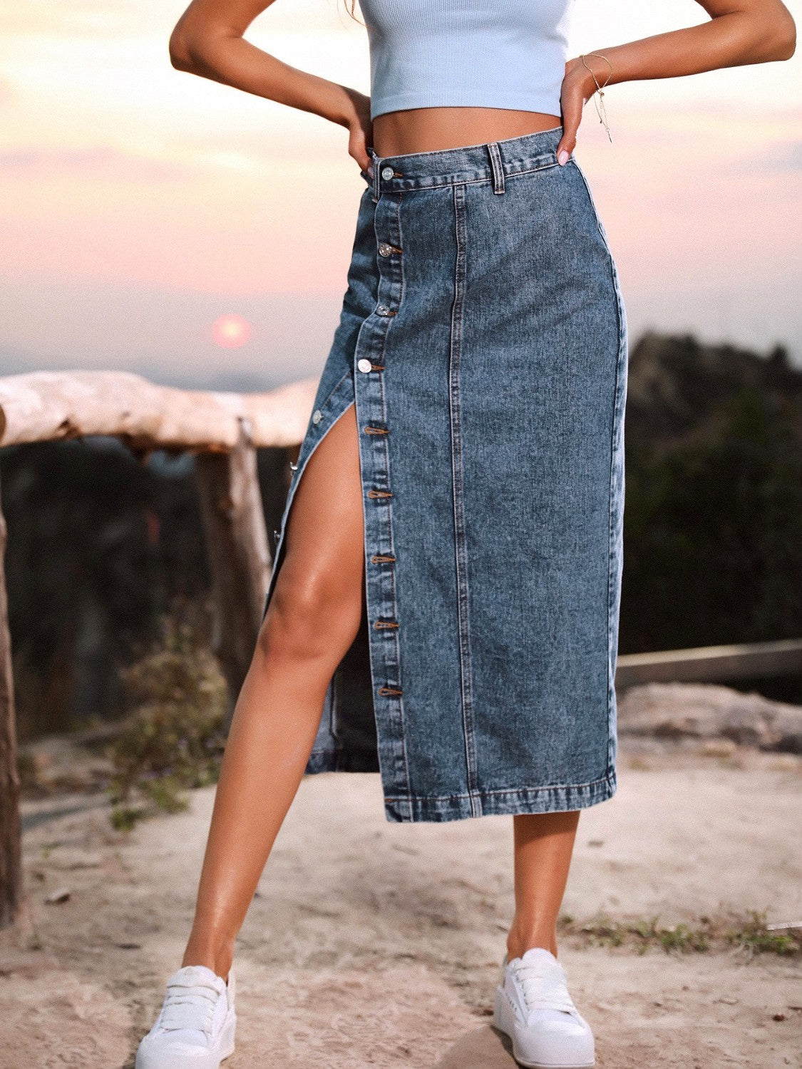 Button-front denim midi skirt in blue with a high slit and button detail.