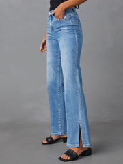 Medium wash flare jeans with distressed details and side leg slits.