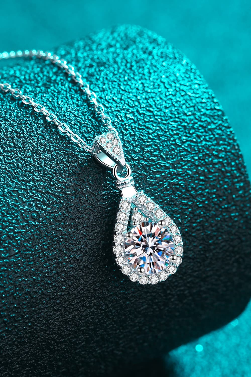Sterling silver necklace with a halo moissanite teardrop pendant and pave accents.