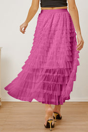 Tiered tulle maxi skirt in pink with a ruffled hem, shown on a woman.