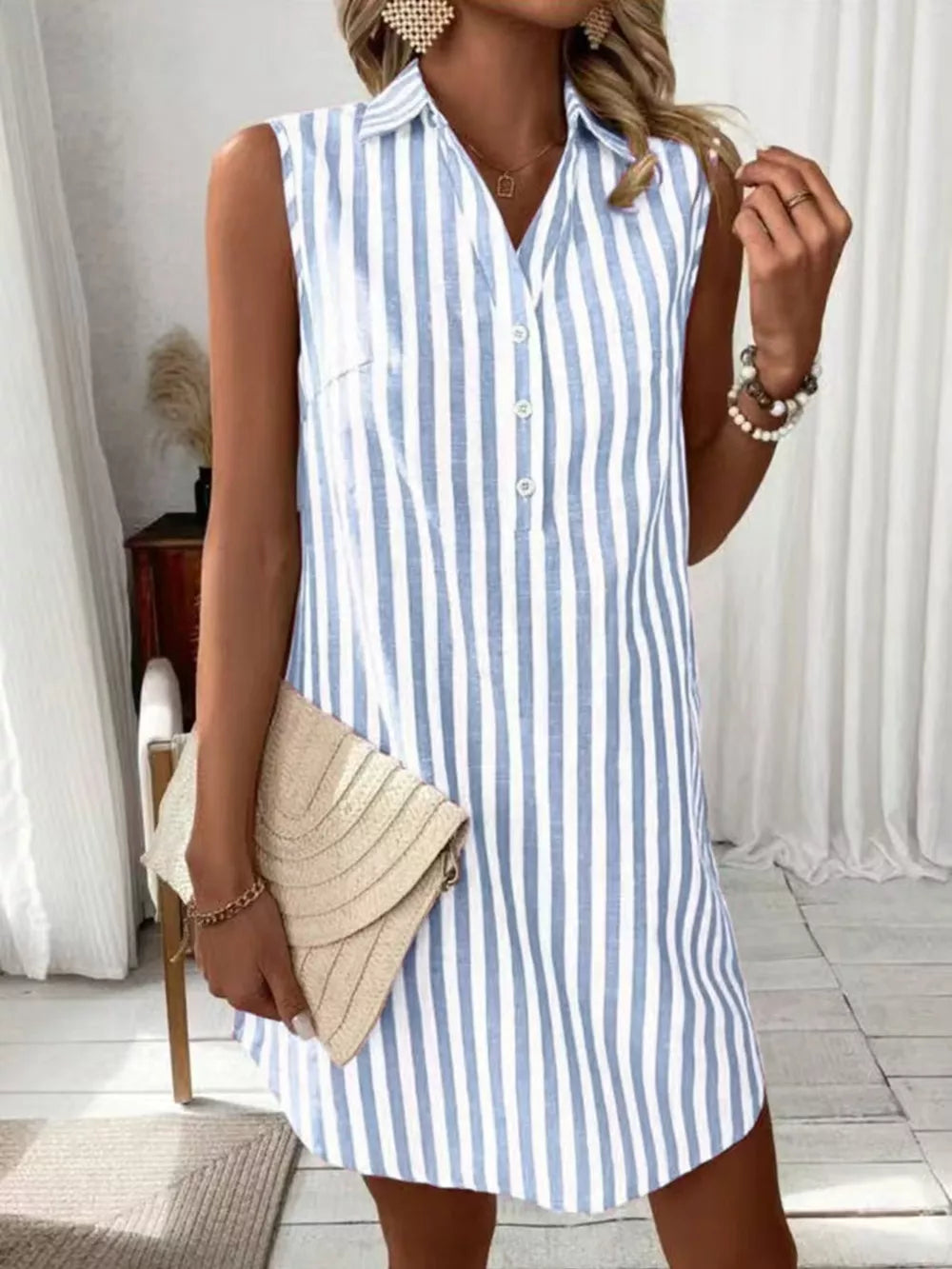 Light blue and white striped collared sleeveless shirt dress with button front.