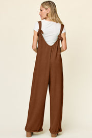 Caramel ribbed knit tie-strap jumpsuit with wide legs and a white t-shirt.