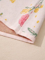 Floral V-neck knit sweater in light pink with yellow and green floral print.