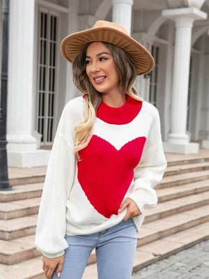 White acrylic sweater with red heart intarsia pattern and red neckline.