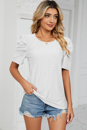 White perforated puff sleeve top with a textured pattern and round neckline.