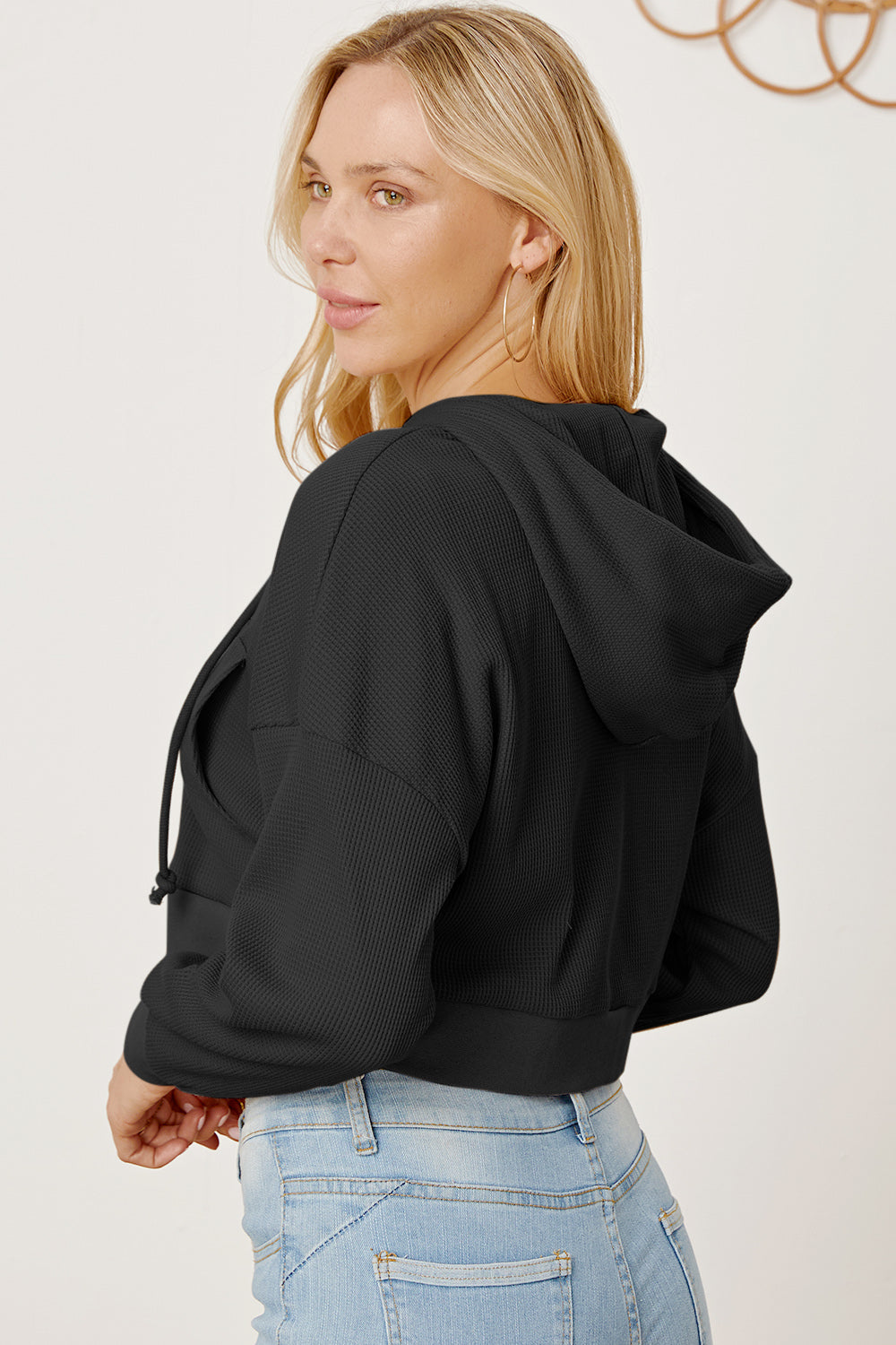 Black waffle knit cropped zip hoodie with drawstring hood and kangaroo pocket.