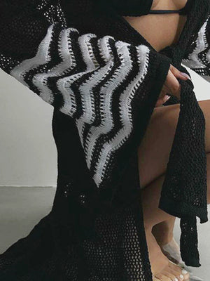 Black knit duster with white chevron pattern on bell sleeves.