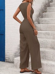Brown wide-leg maternity jumpsuit with tied waist and textured fabric.