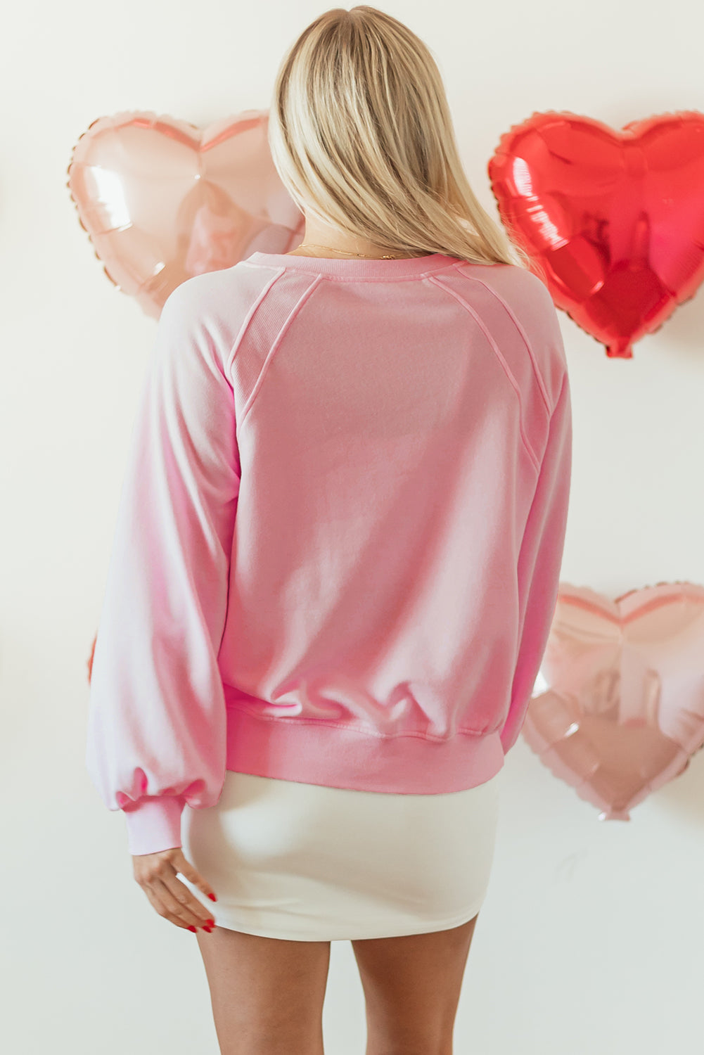 Blush pink off-shoulder sweatshirt with balloon sleeves and a relaxed fit.