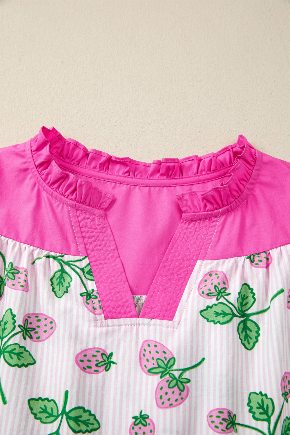 Strawberry print cotton blend blouse with color block pink top and ruffled neckline.