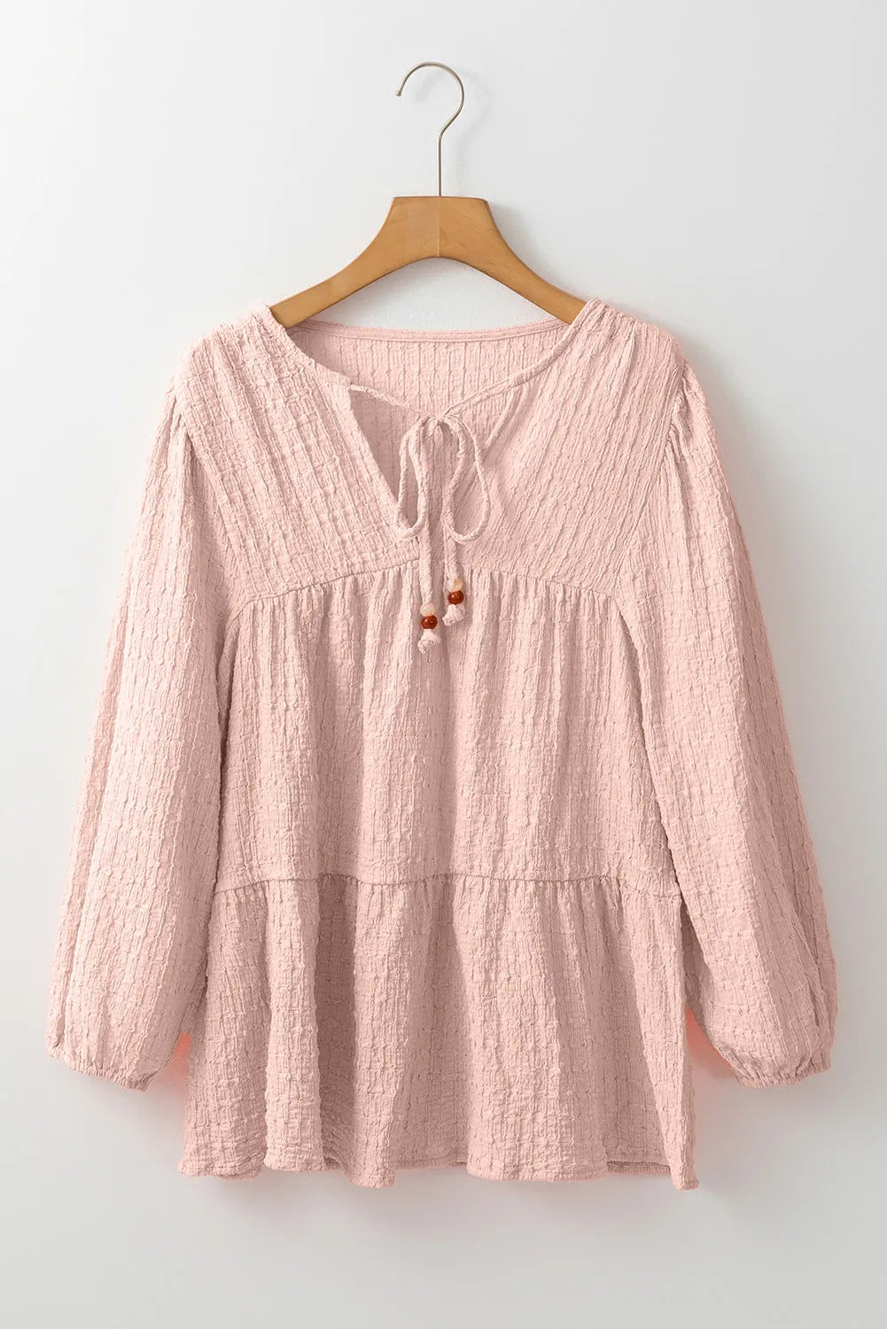 Watermelon pink textured tiered blouse with tie detail and beaded accents.