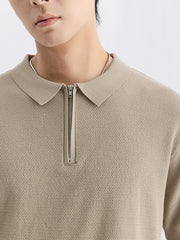 Textured knit zip-up polo shirt in apricot with a silver zipper and collar.