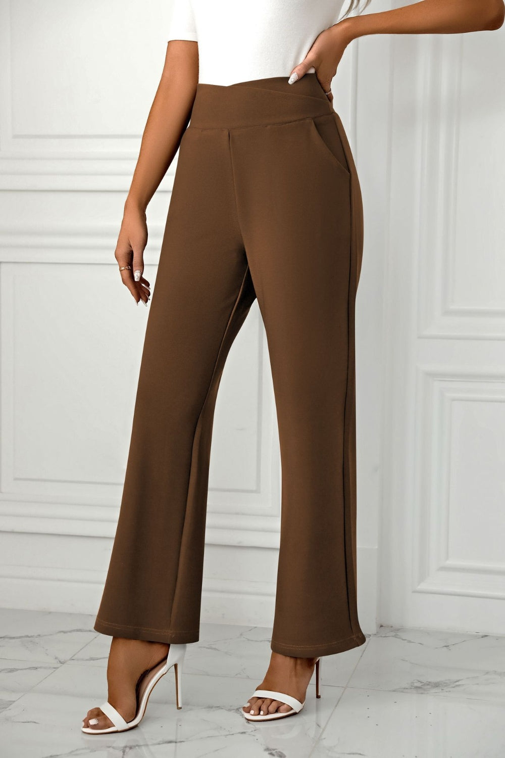 Brown wide-leg trousers with a sculpted waist and pockets.