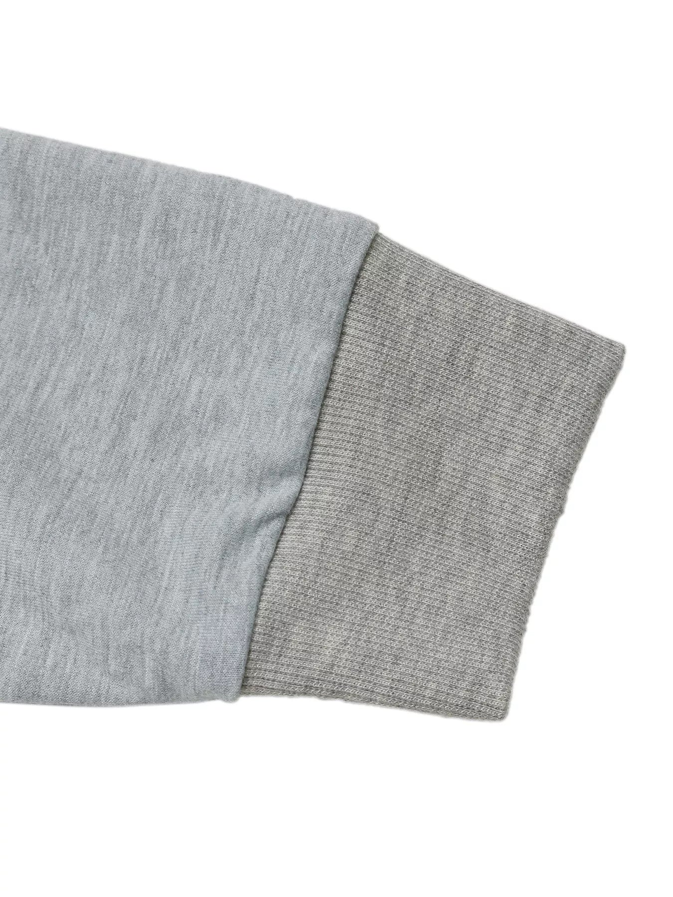 Gray sweatshirt sleeve detail with ribbed cuff and contrasting fabric texture.