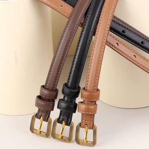 Sleek cowhide leather accent belts in brown, black, and caramel with antique brass buckles.
