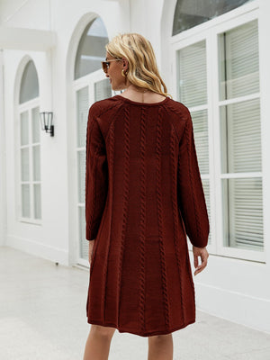 Cable knit A-line sweater dress in wine with vertical cable details and long sleeves.