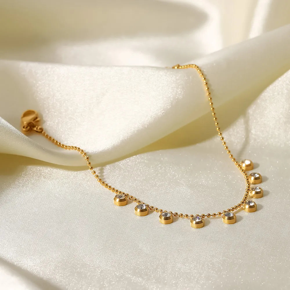 Gold-plated necklace with delicate pavé charms on a beaded chain