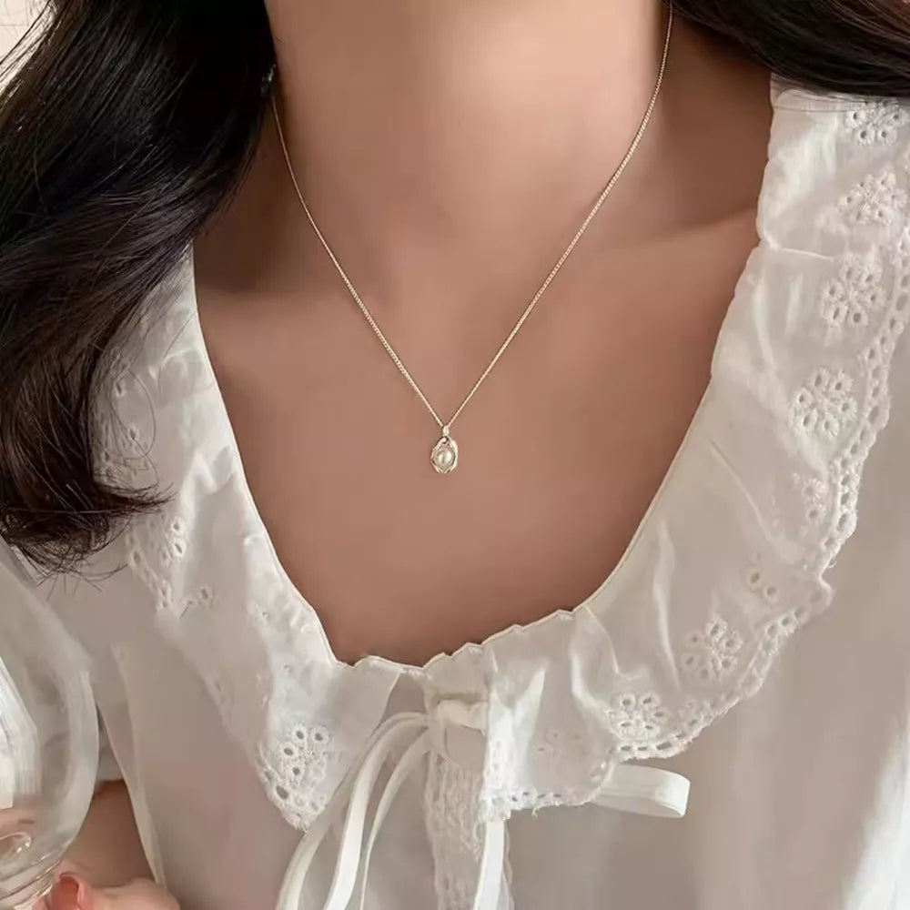 Sterling silver necklace with single freshwater pearl pendant, gold tone.