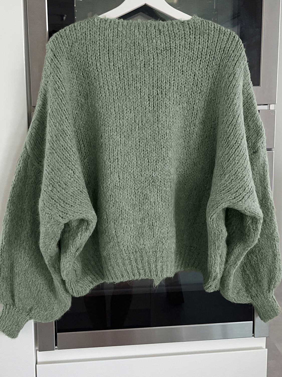 Moss green knit cardigan with balloon sleeves and lace-up detail