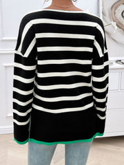 Black and white striped oversized knit top with a green hem detail.