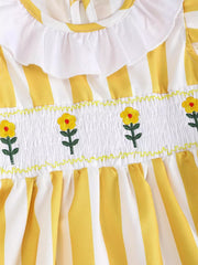 Yellow and white striped baby dress with smocked floral bodice and ruffle collar.