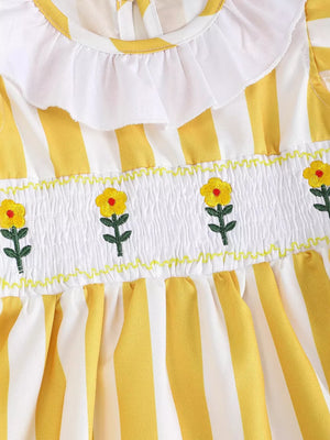 Yellow and white striped baby dress with smocked floral bodice and ruffle collar.
