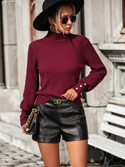 Burgundy turtleneck knit sweater with pearl cuff details and ribbed sleeves.