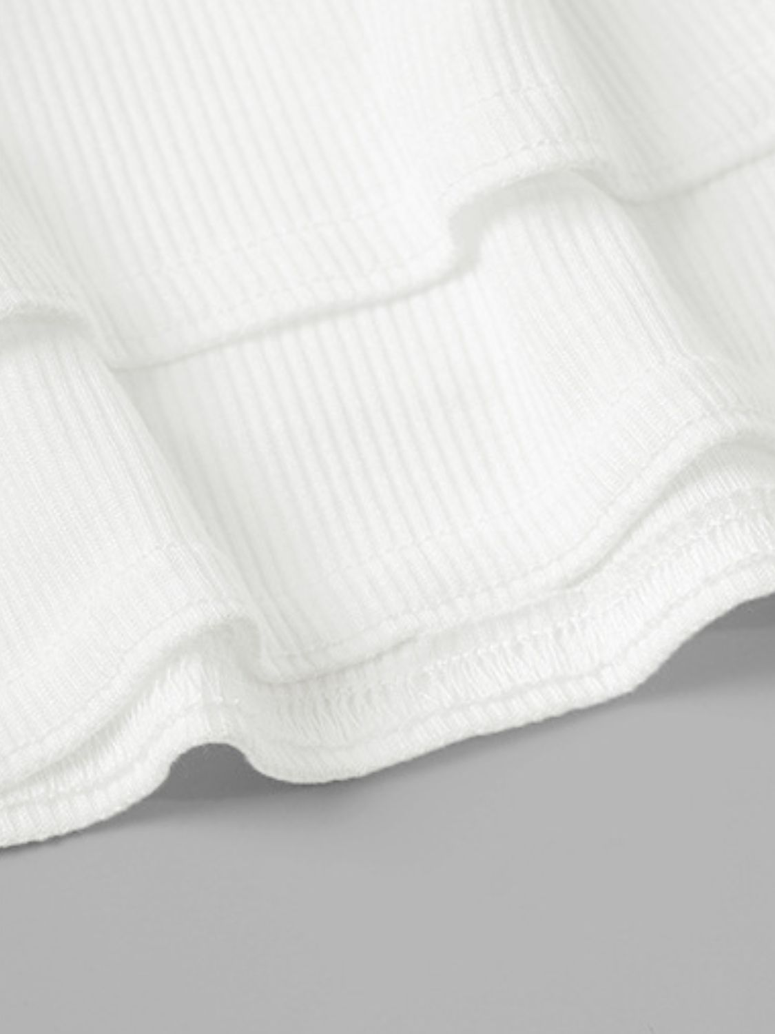 White ribbed tiered mini skirt detail with ruffled hem