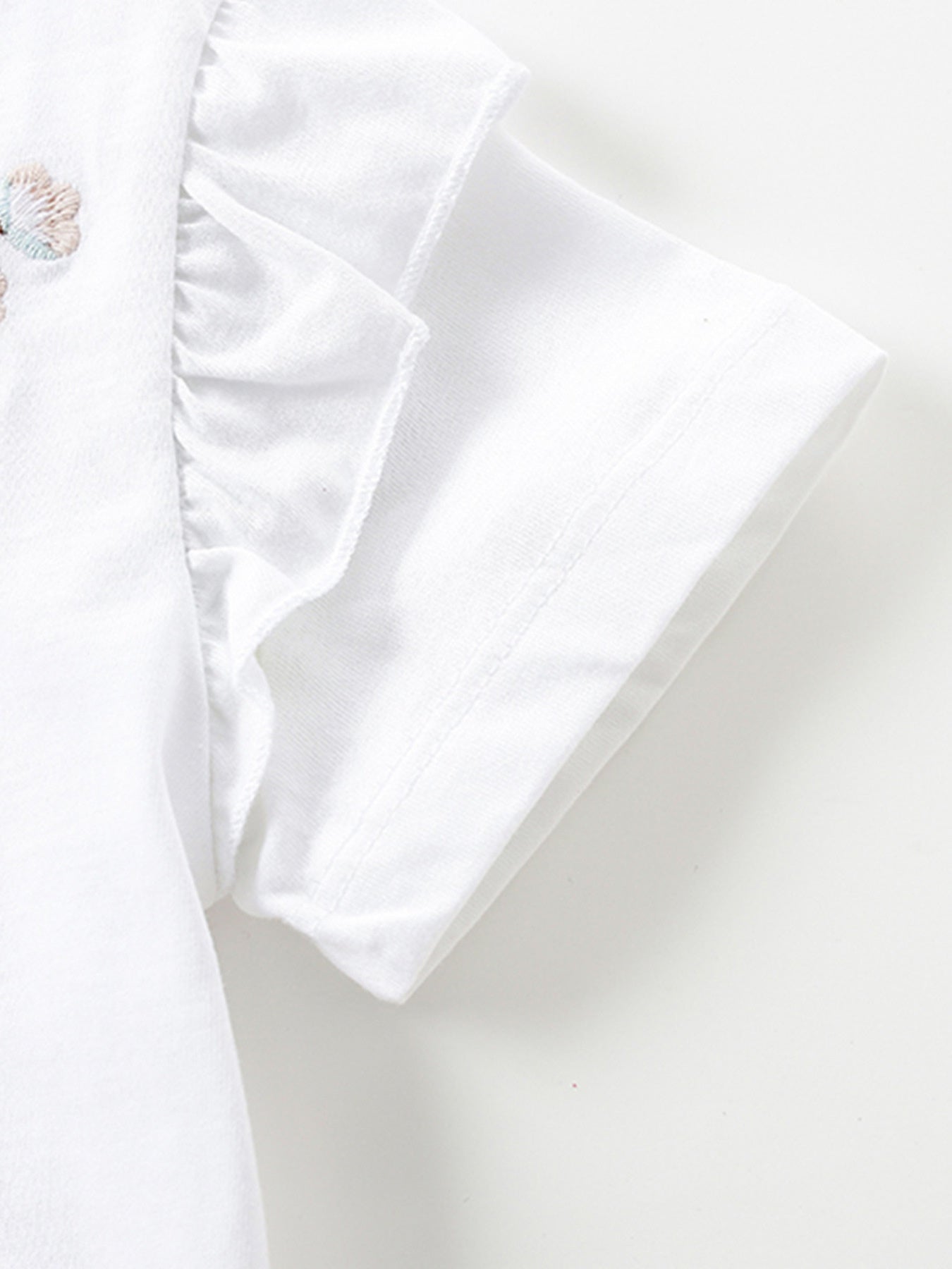 White toddler dress with embroidered butterfly detail and ruffled sleeves.
