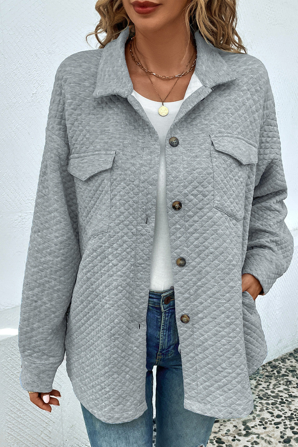 Quilted overshirt in grey with patch pockets and button front, styled casually.