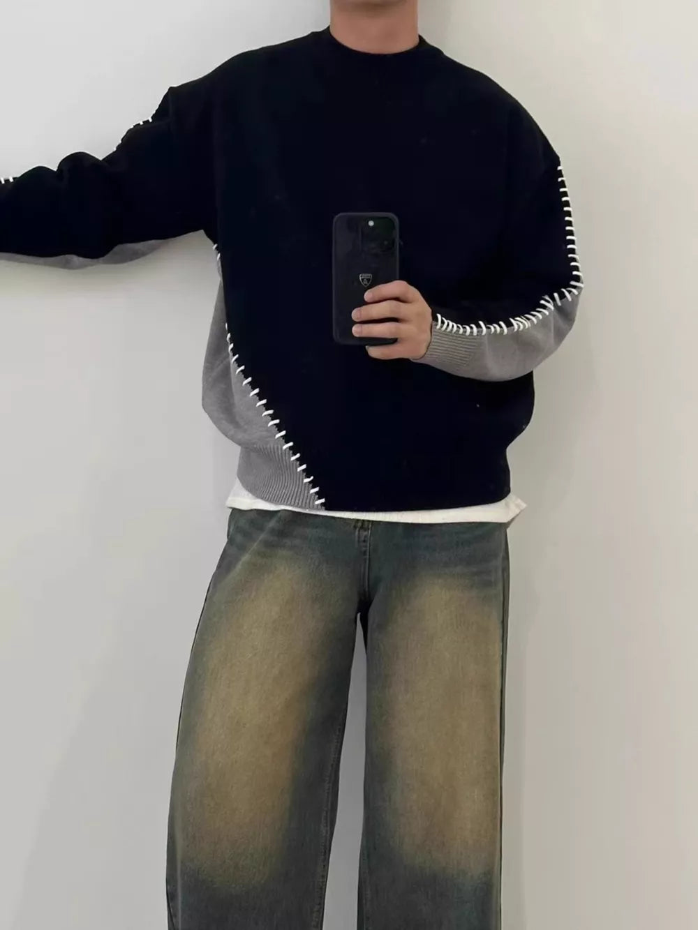 Men's black and gray two-tone mock neck sweater with contrast stitching detail.
