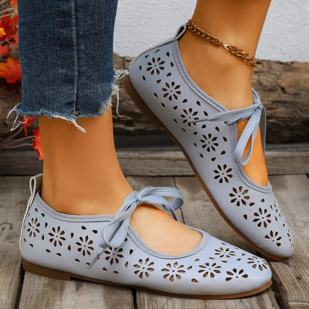 Sky blue floral cutout slip-on flats with tie detail and ankle chain.
