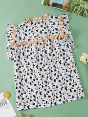 White blouse with terrazzo print, ruffle yoke, and short sleeves.