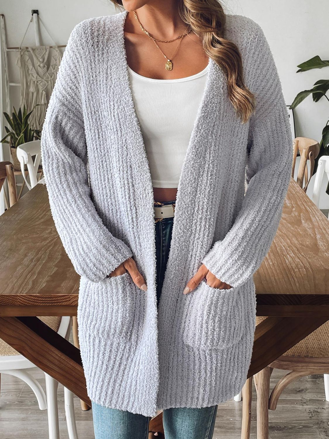 Gray textured bouclé open-front cardigan with pockets, styled casually.