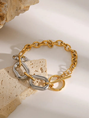 Two-tone chain link bracelet with toggle clasp and oval links in gold and silver tones.