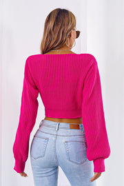 Hot pink acrylic knit crop sweater with balloon sleeves and tie front detail.