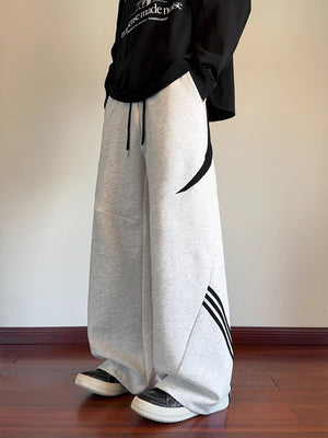 Light gray wide-leg sweatpants with black stripe accents and drawstring waist.